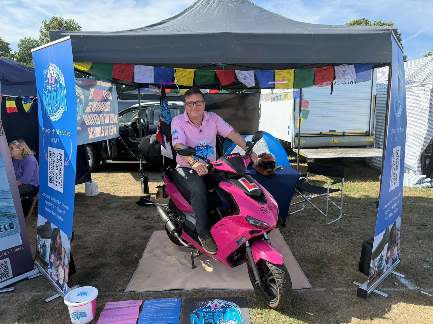 Tony Hobden on the pink scooter, with L plate, at a Scoot 4 Nepal stand
